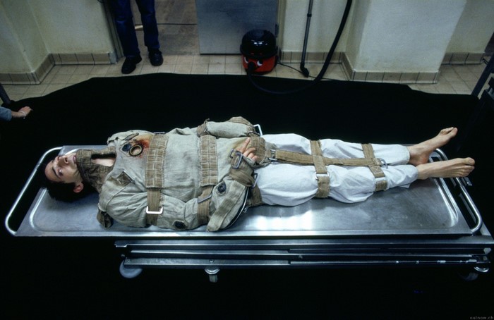 Adrien Brody in a straitjacket on a gurney