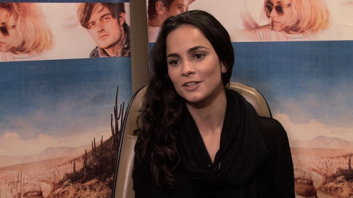 Alice Braga in front of movie poster