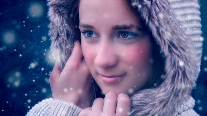 Girl in a hooded coat in the snow
