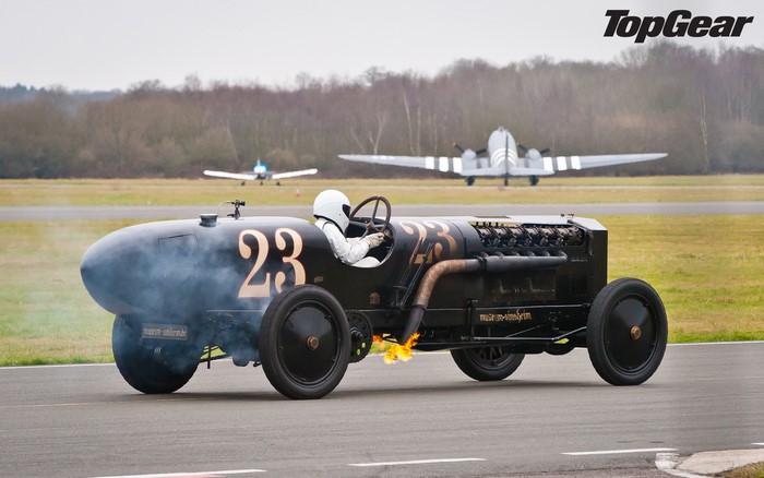 Ben Collins driving a vintage race car with flames