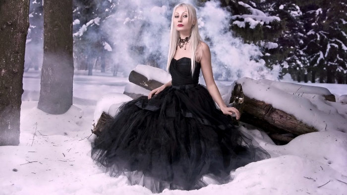 Woman in black dress in snowy forest