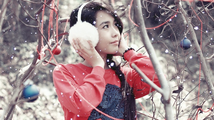 Girl wearing earmuffs and red sweater with ornaments