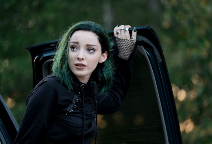 Emma Dumont leaning on car door