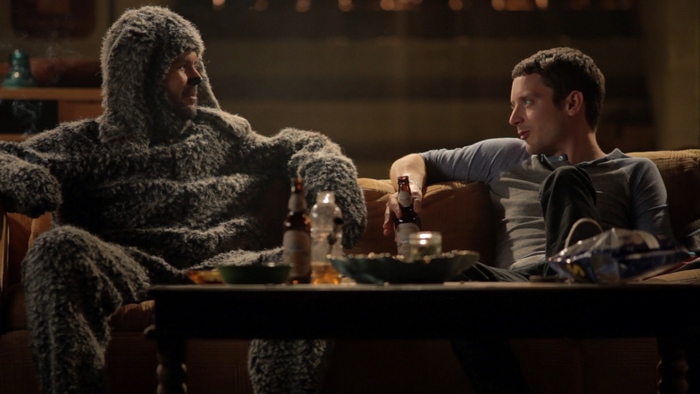 Man in furry costume and Elijah Wood with beer