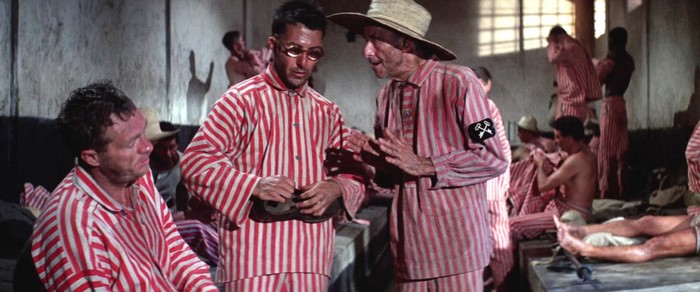 Prisoners in striped uniforms in a barracks