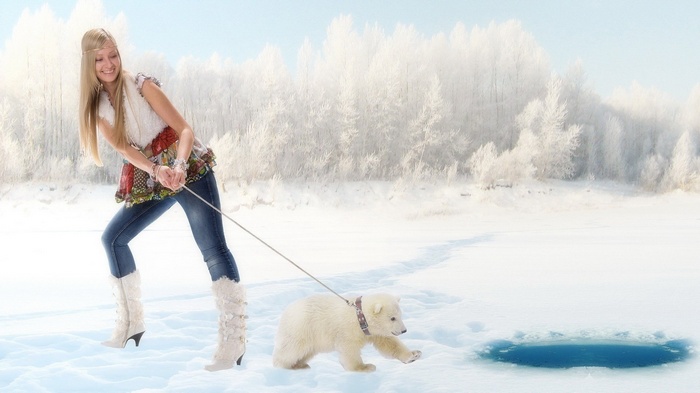 Woman walking a polar bear cub on a leash in the snow