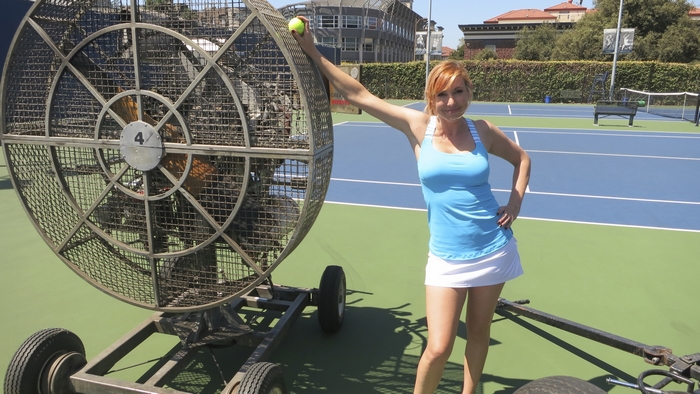 Kari Byron with a large fan on a tennis court