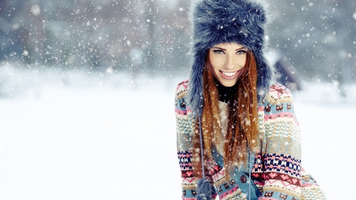 Woman in winter hat and sweater in snow