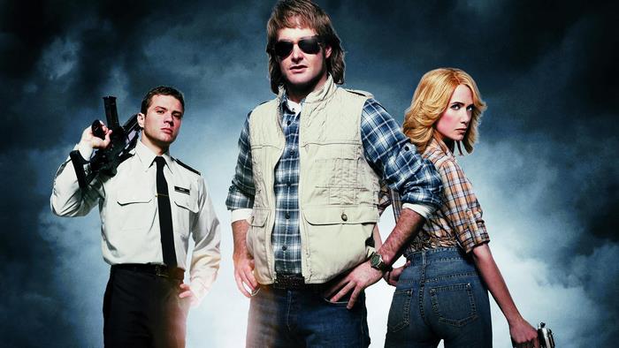 Kristen Wiig and two men with guns