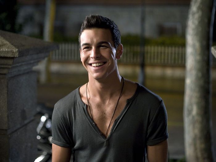 Mario Casas smiling outdoors at night