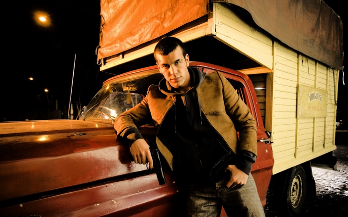 Mario Casas leaning on a truck
