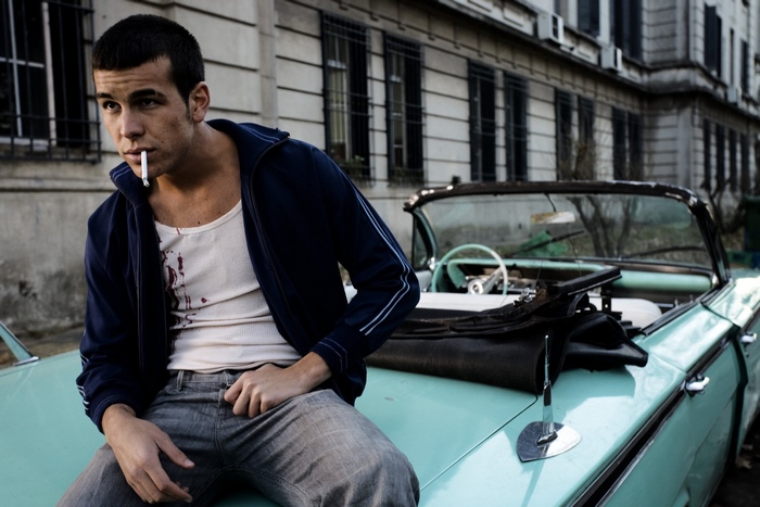 Mario Casas sitting on a car