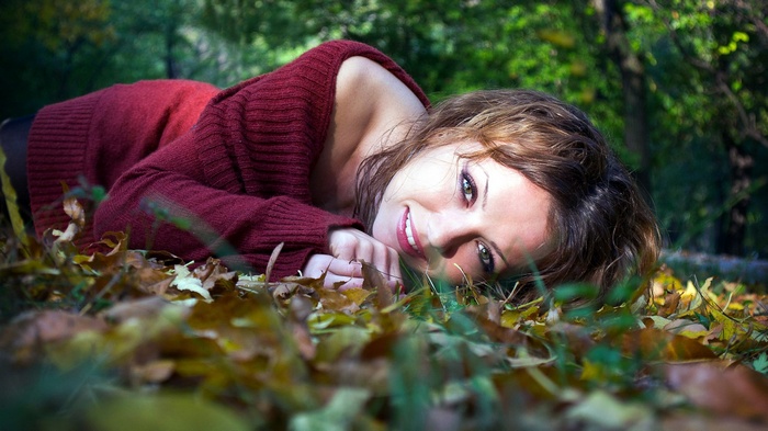 Woman lying in autumn leaves