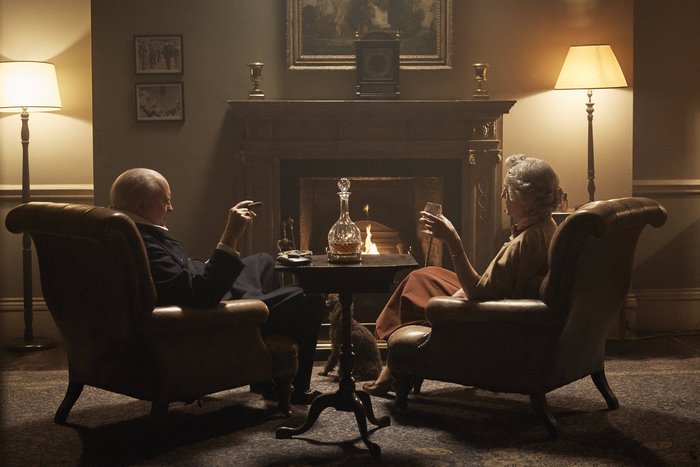 Winston Churchill in armchairs by fireplace