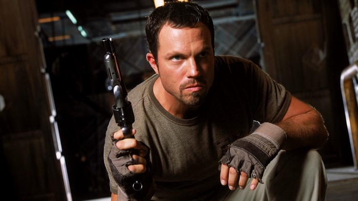Adam Baldwin holding a gun