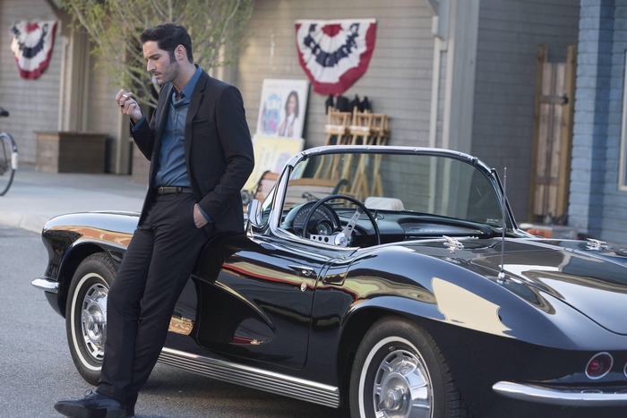 Tom Ellis leaning on a vintage car