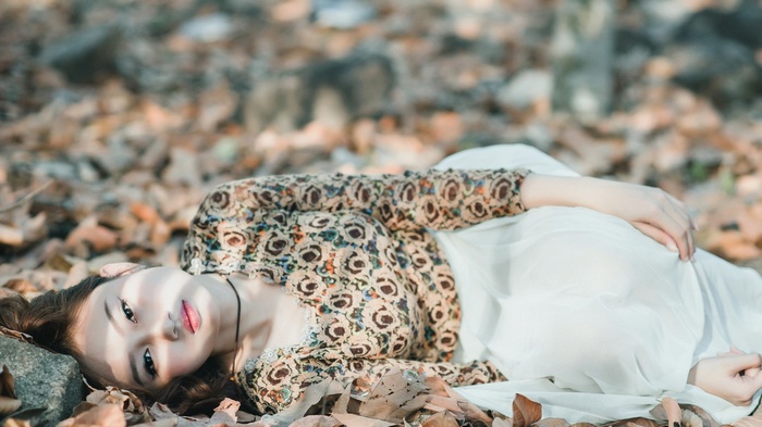Woman lying on autumn leaves