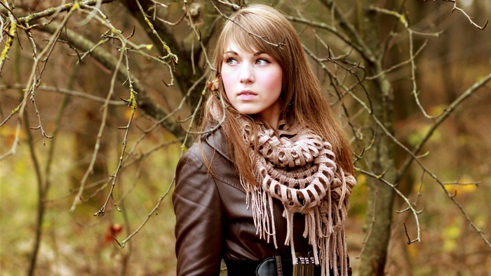 Young woman in a brown jacket and scarf outdoors