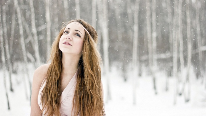 Young woman with long hair in a snowy forest