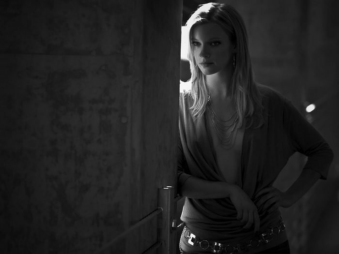 Amy Smart posing in a dimly lit room