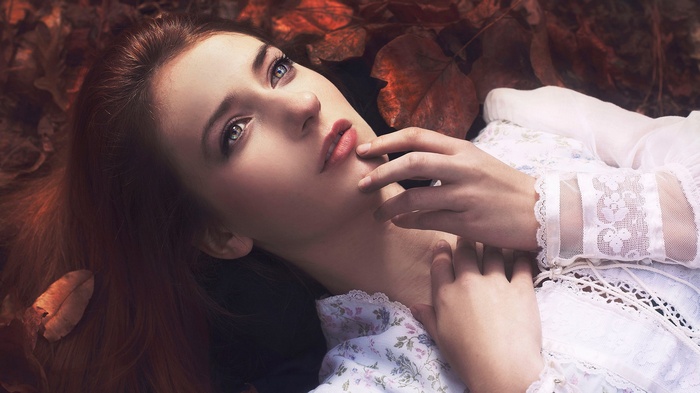 Woman lying in autumn leaves