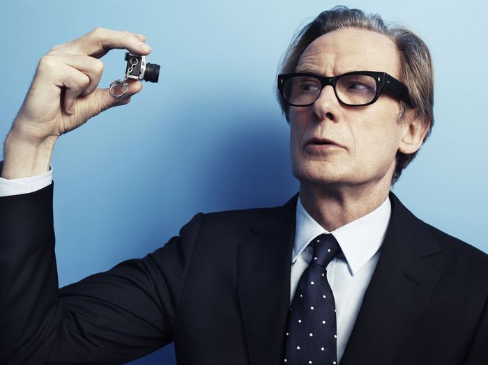 Bill Nighy holding a miniature camera