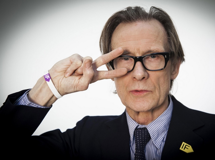 Bill Nighy wearing glasses and a suit