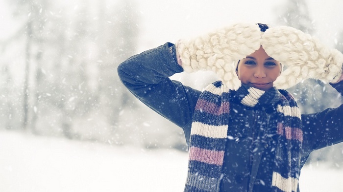 Woman in winter clothes holding large mittens