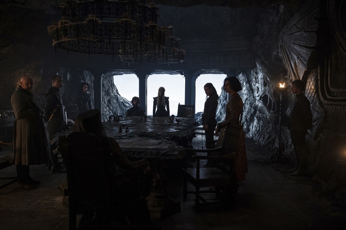 People gathered around a large table in a dark room
