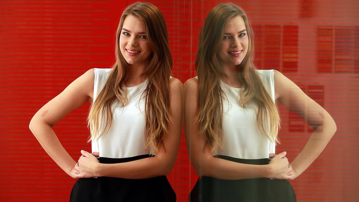 Indiana Evans posing in front of a red background
