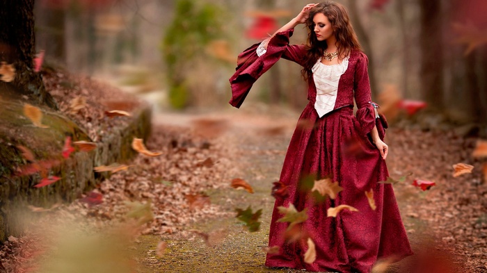 Woman in a red dress in an autumn forest