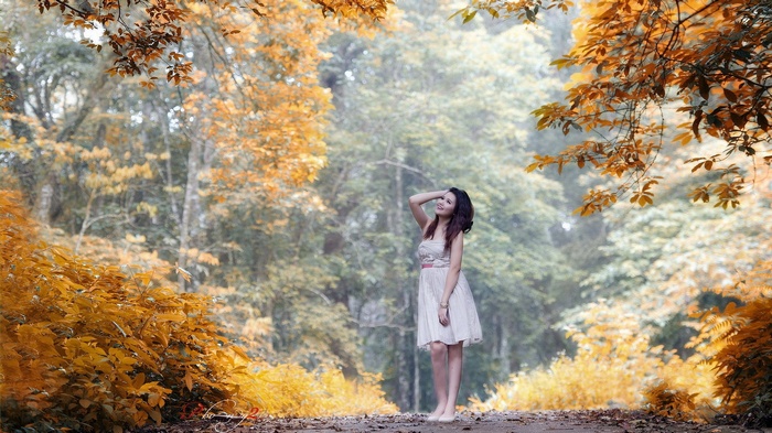 Woman in a white dress in an autumn forest
