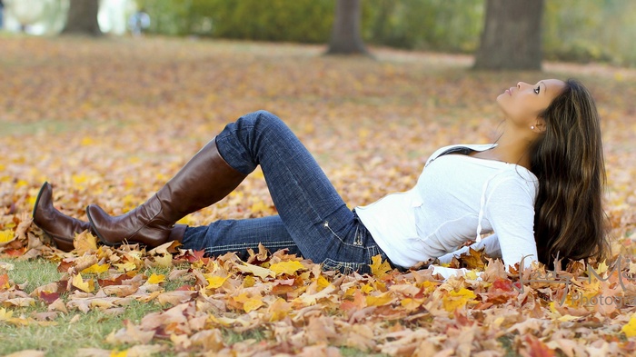 Woman lying in autumn leaves