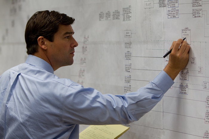 Kyle Chandler writing on a flowchart