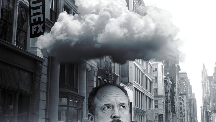 Louis C.K. in a city with a cloud overhead