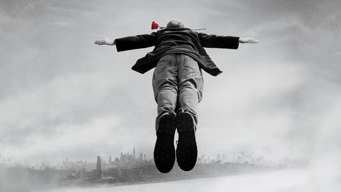 Louis C.K. flying with a rose