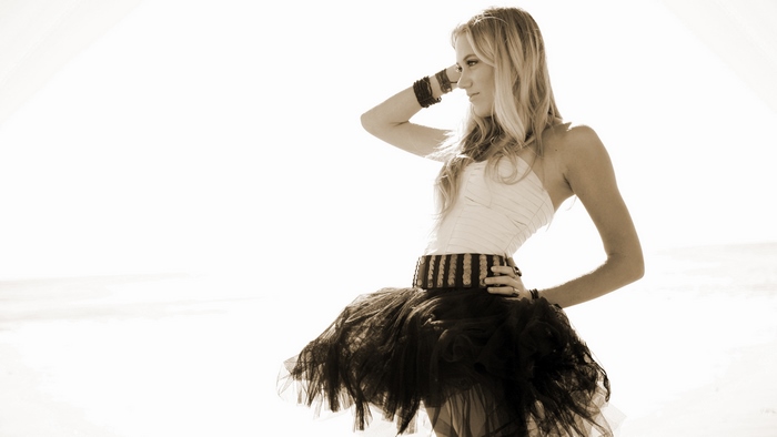 Maika Monroe in a white top and black skirt