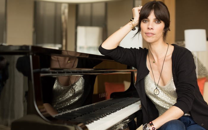 Maribel Verdú sitting by a piano