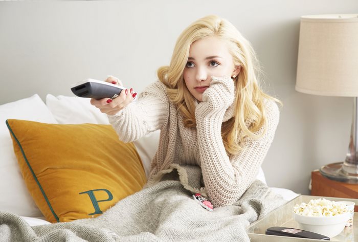 Peyton List watching TV with popcorn