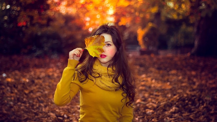 Woman holding a leaf in front of her eye