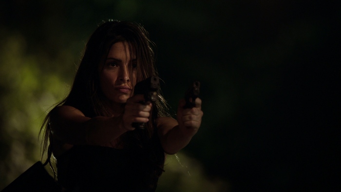 Sarah Shahi holding two pistols