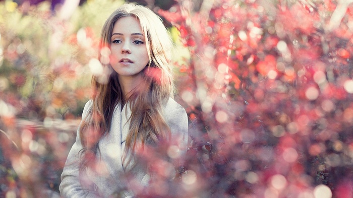 Young woman with blonde hair in a coat outdoors