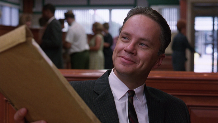Tim Robbins holding a manila envelope