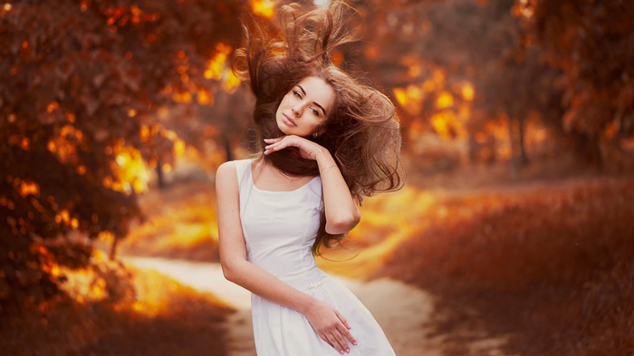 Woman with long hair in a white dress outdoors