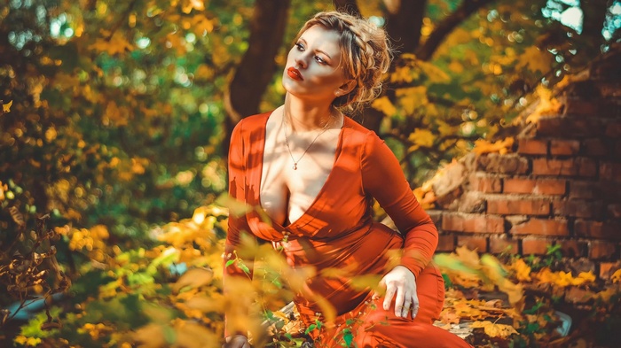 Woman in orange dress in autumn forest