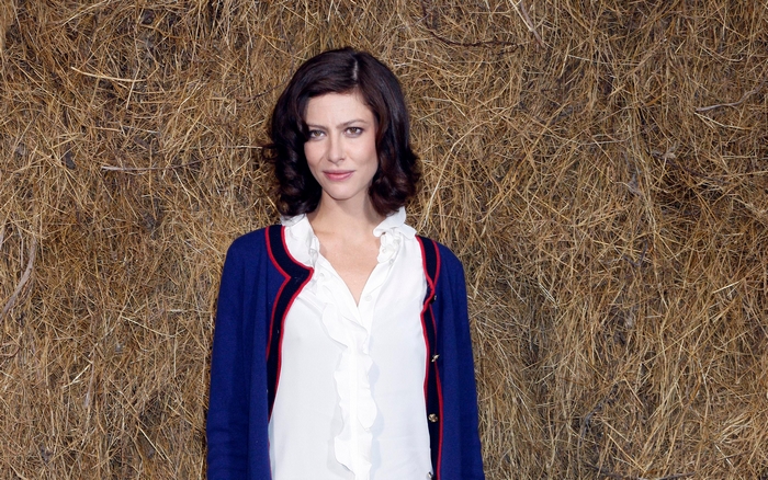 Anna Mouglalis in front of a hay bale background