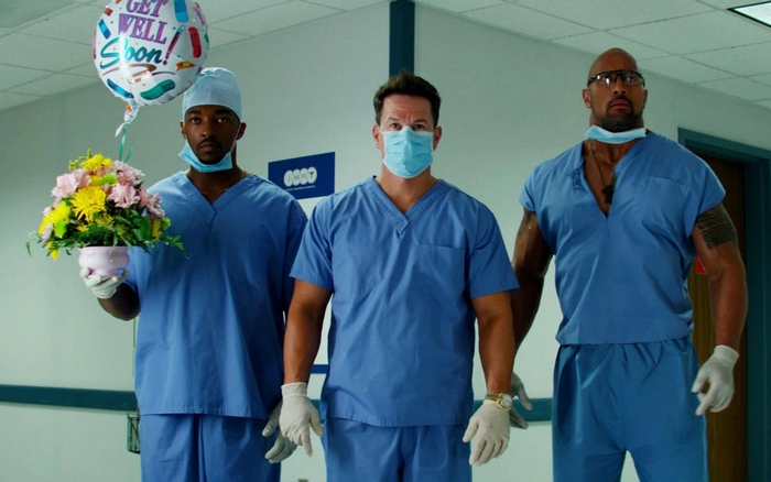 Three men in scrubs in a hospital hallway