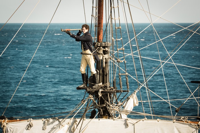 Benjamin Walker on a ship's mast with spyglass
