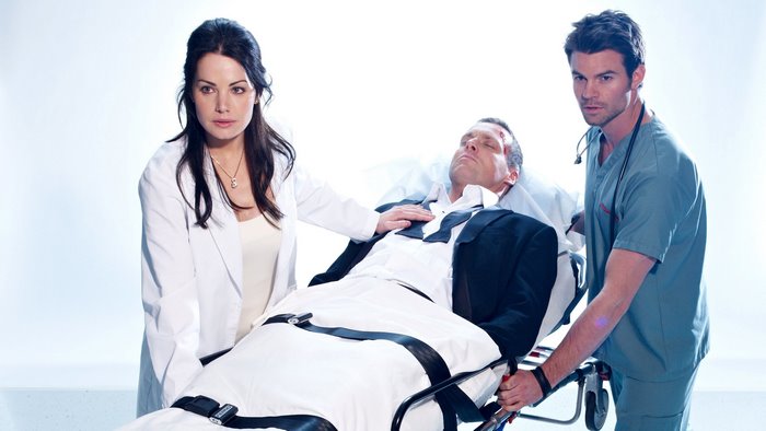 Erica Durance and two men with a patient on a gurney