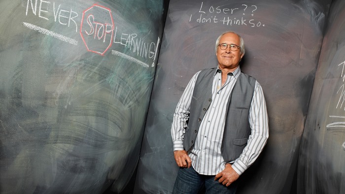 Chevy Chase in front of chalkboards